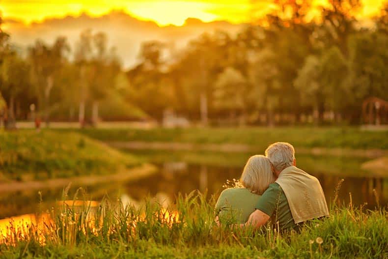 A senior couple relaxing in a park on a summer day.