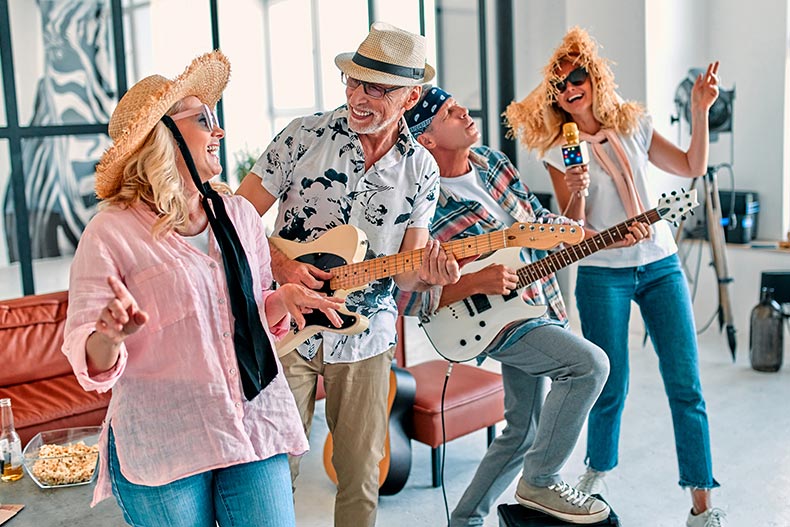 A group of 55+ friends singing and playing guitars.