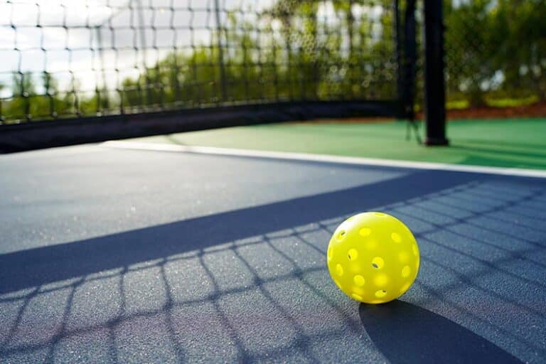 Close up of a pickleball on a pickleball court.