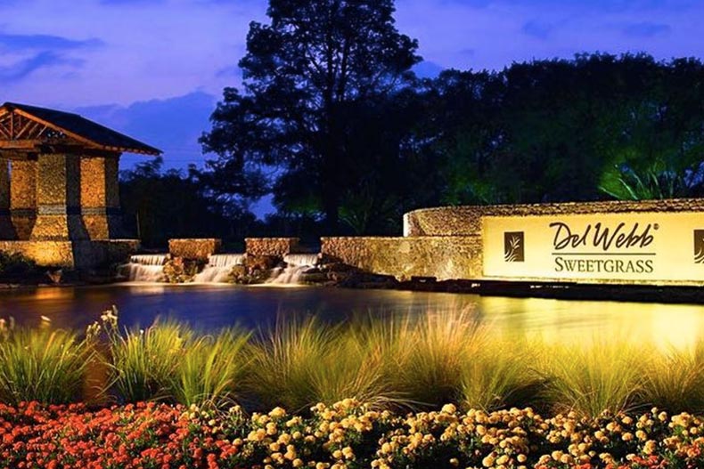 Nighttime view of the community sign for Del Webb Sweetgrass in Richmond, Texas.