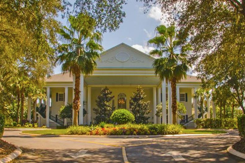 Palm trees and greenery surrounding a community building at Plantation at Leesburg in Leesburg, Florida.