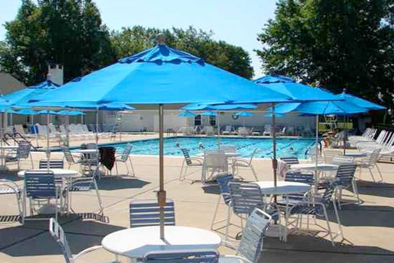 Tables and chairs beside the outdoor pool at Rossmoor Village in Monroe, New Jersey.