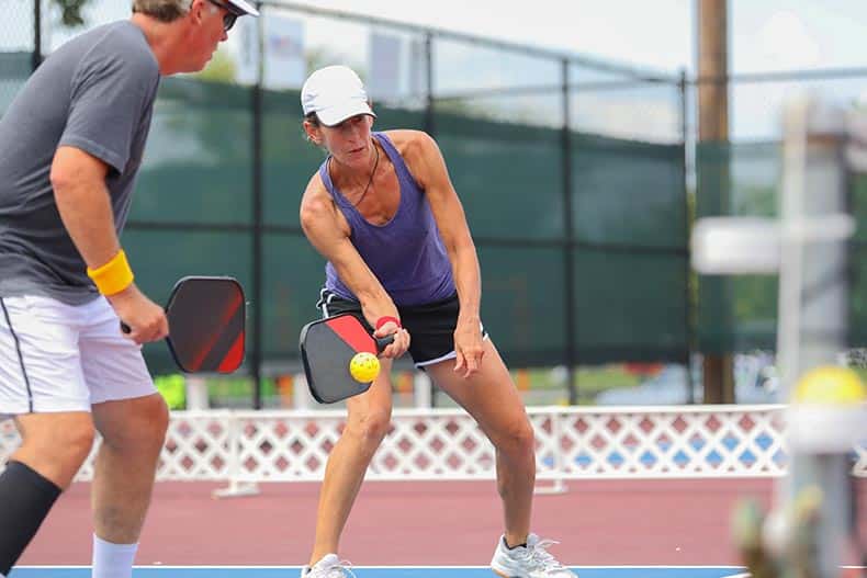 A mixed doubles team competes in a pickleball tournament.