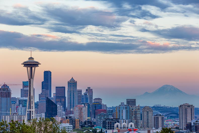 Clouds in the sky and a mountain behind the Seattle, Washington skyline.