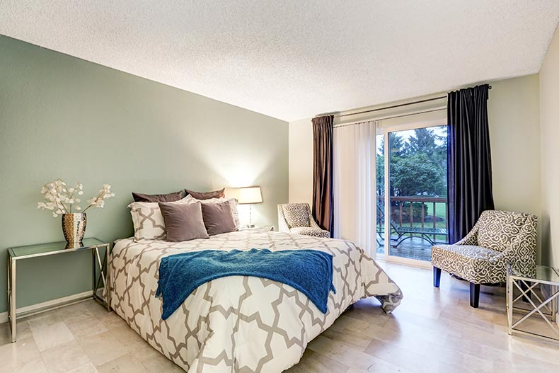 A master bedroom with a pale green accent wall.