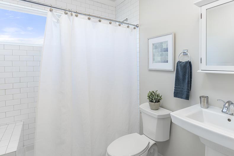 A clean, white bathroom with a white shower curtain.