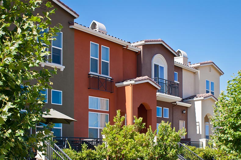 A row of new townhomes with yellow, gray, and dark red exteriors in San Jose, California.