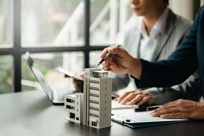 A pair of bankers approving a loan for a 55+ condo purchase.