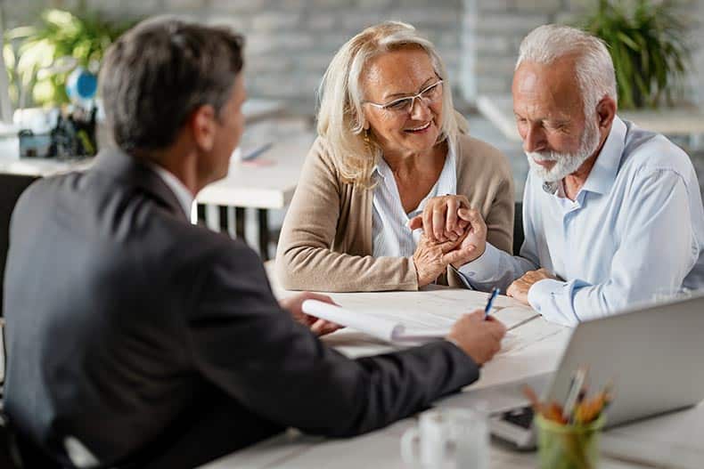 A retired couple buying a home with a real estate agent.