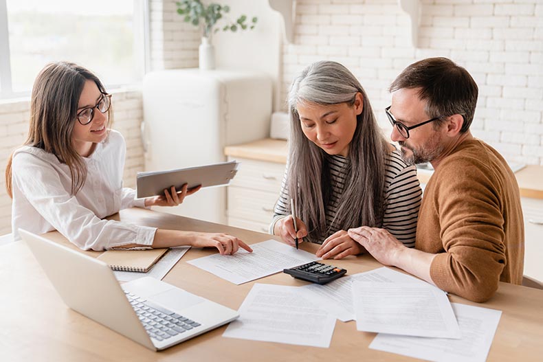 A retired couple buying a home in a 55+ community with their real estate agent.