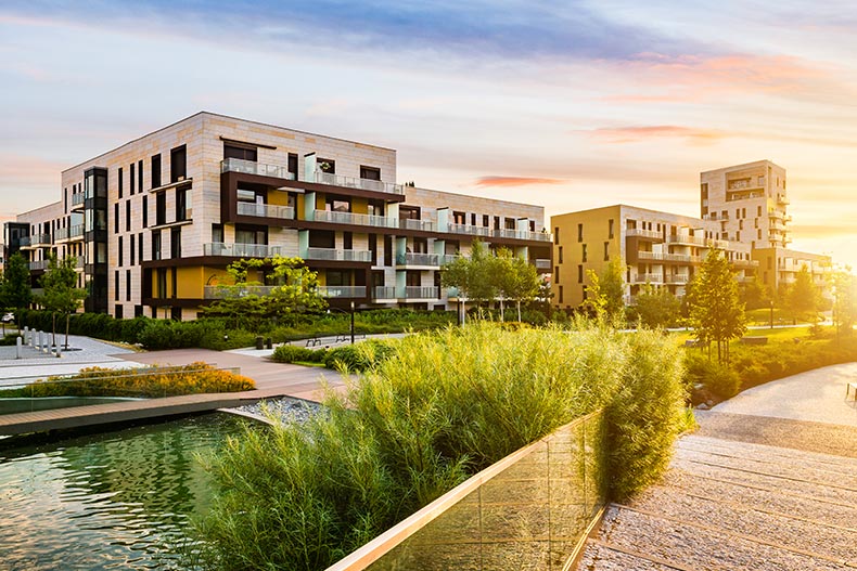 A condo building beside a public park at sunrise.