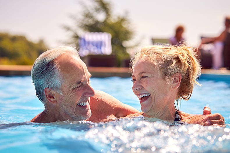 A retired couple relaxing in the swimming pool in their 55+ community.