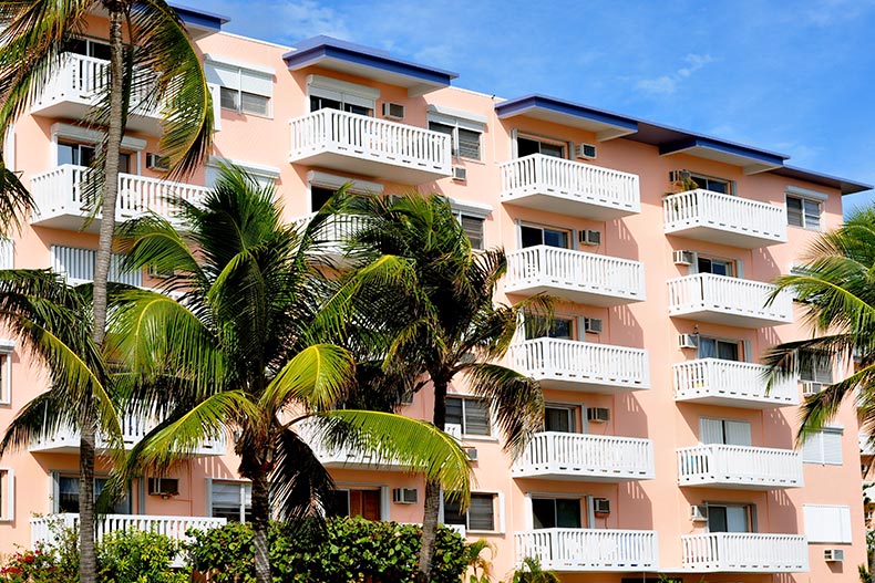 Palm trees in front of a condo building in a tropical location.