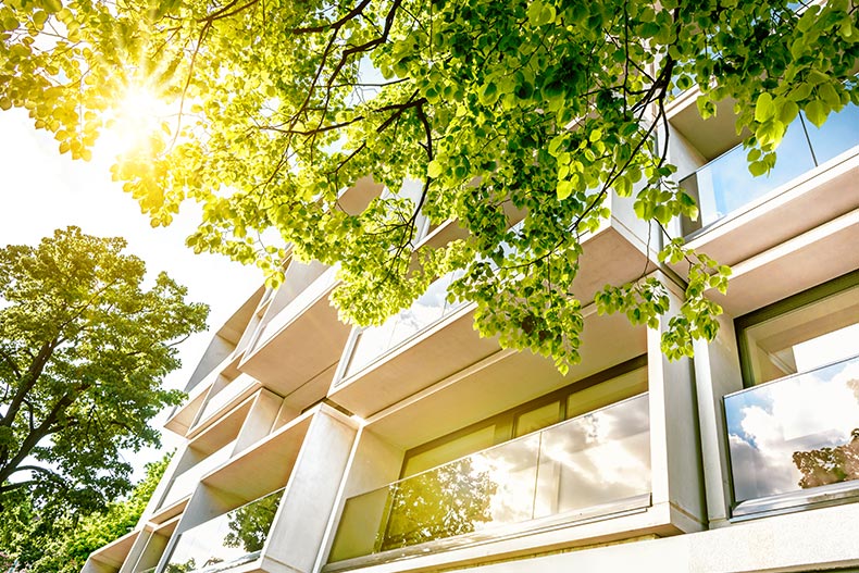 Sunlight on the windows of a modern white condo building.