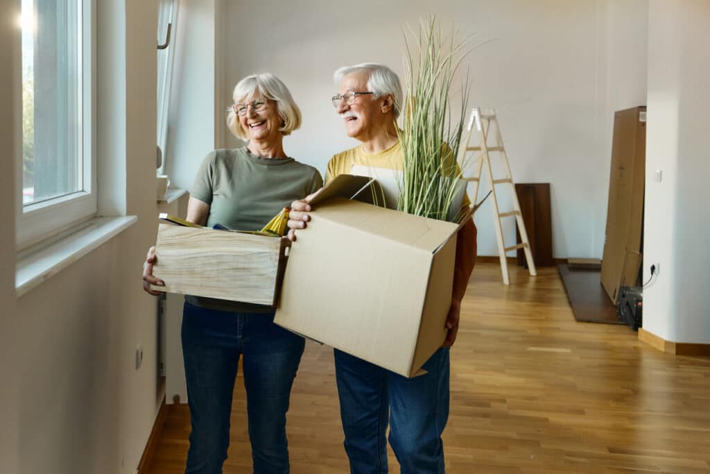 55+ couple moves boxes into their new home in a 55+community.