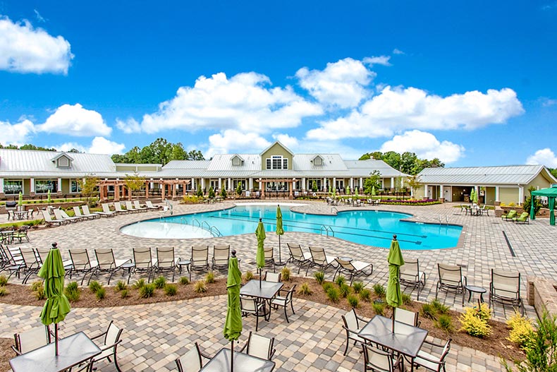 Chairs and tables surrounding the outdoor pool at Cresswind Charlotte in Charlotte, North Carolina.