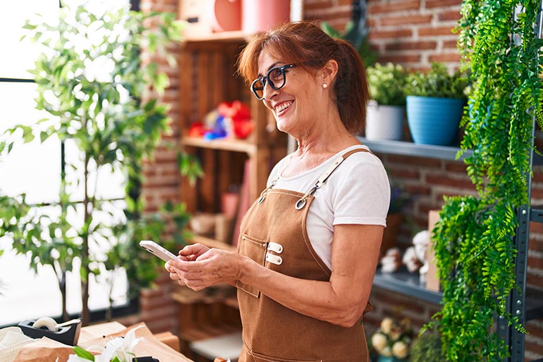 An active adult woman smiling while working at a flower shop.