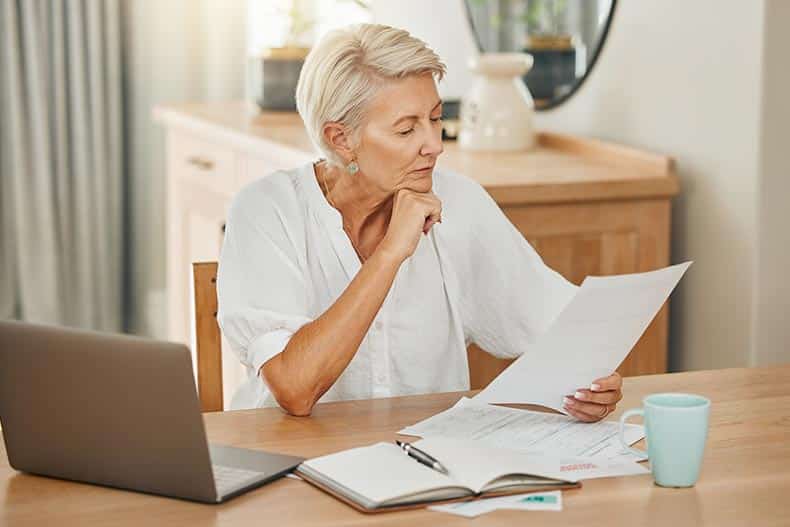 A 55+ woman looking over a document detailing her HOA bylaws.