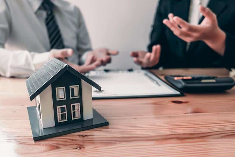 Customer signs the house insurance contact after listening to the contact agreement from an agent.