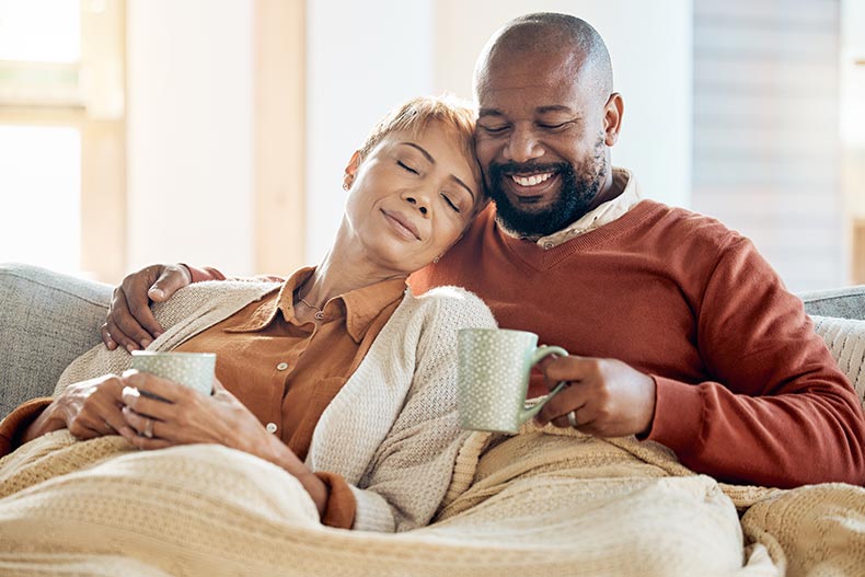 A 55+ couple relaxing on a sofa in their new home.