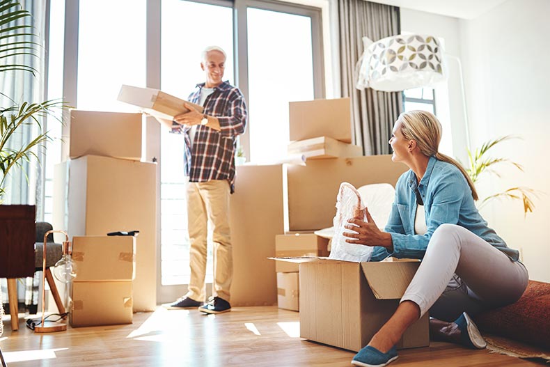 A senior couple packing boxes together and preparing to move to a 55+ community.