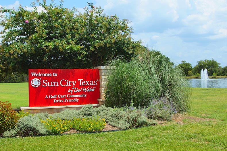 Greenery surrounding the community sign for Sun City Texas in Georgetown, Texas.