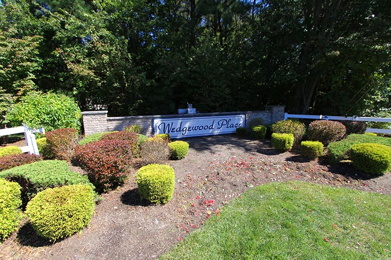 Greenery surrounding the community sign for Wedgewood Place in Brick, New Jersey.