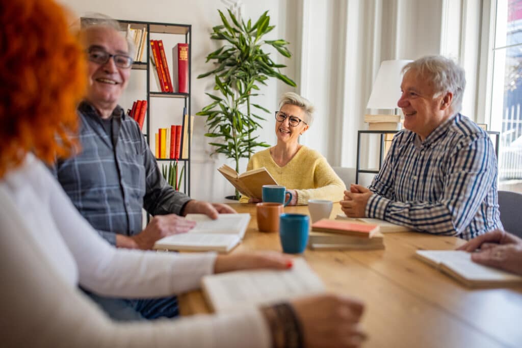 A group of 55+ adults discuss activities at adult communities.