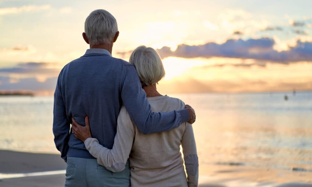A retired couple watch the sunset of one of Florida's beaches.