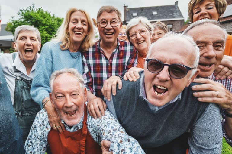 A group of baby boomers laughing and enjoying their active adult community.