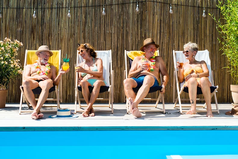 A group of 55+ friends lounging by the outdoor pool in their gated 55+ community.