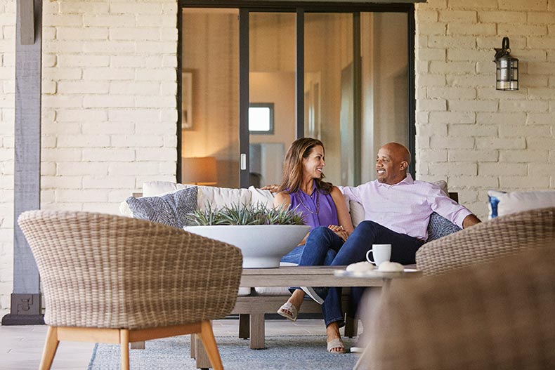 A 55+ couple relaxing outside of their home in a 55+ community.