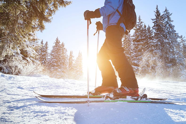 Closeup on a skier on a snowy mountain in the sunshine.