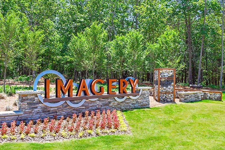 Trees and grass surrounding the community sign for Imagery in Mount Holly, North Carolina.