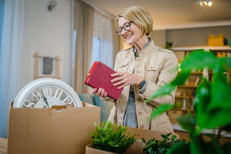 An active adult woman packing items as she prepares to move into a 55+ community.