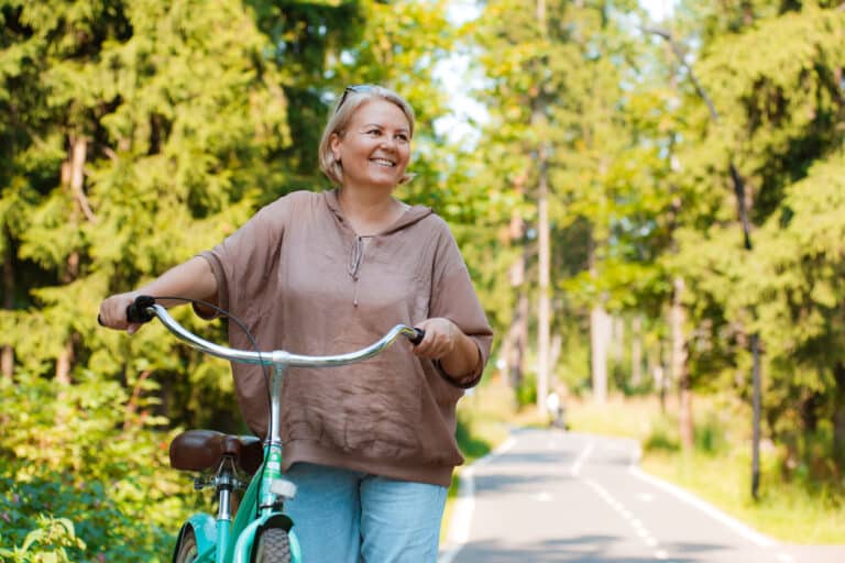 Active adult woman enjoys biking in a 55+ community.