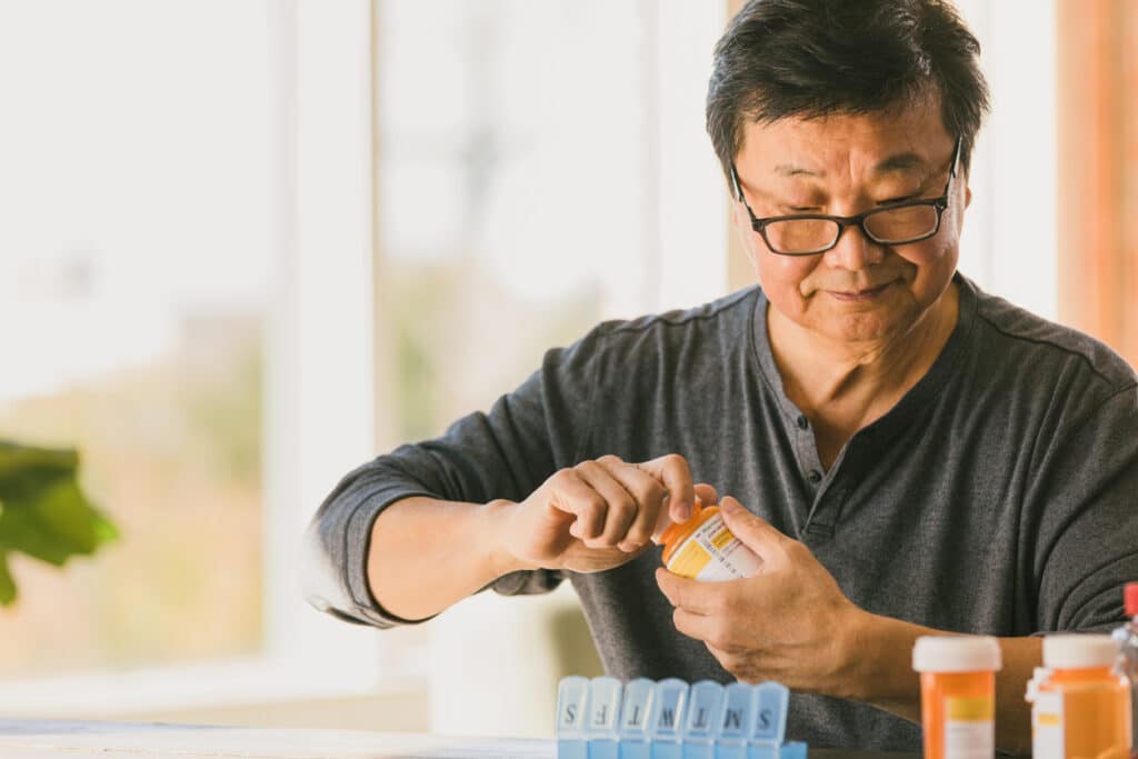 Retired man counts pills in his home in a 55+ community.