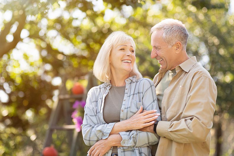 Loving retired spouses enjoying time together in a park.