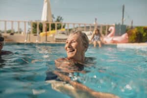 Retired woman enjoys swimming in her active adult community.