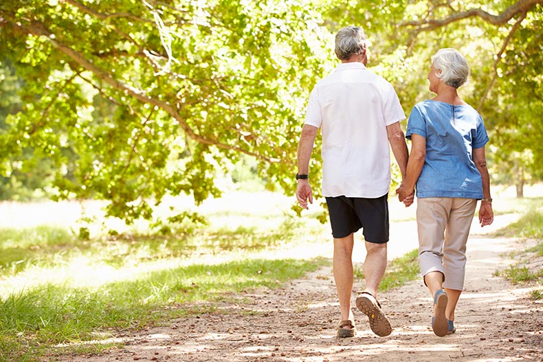 A senior couple walking together in the countryside.