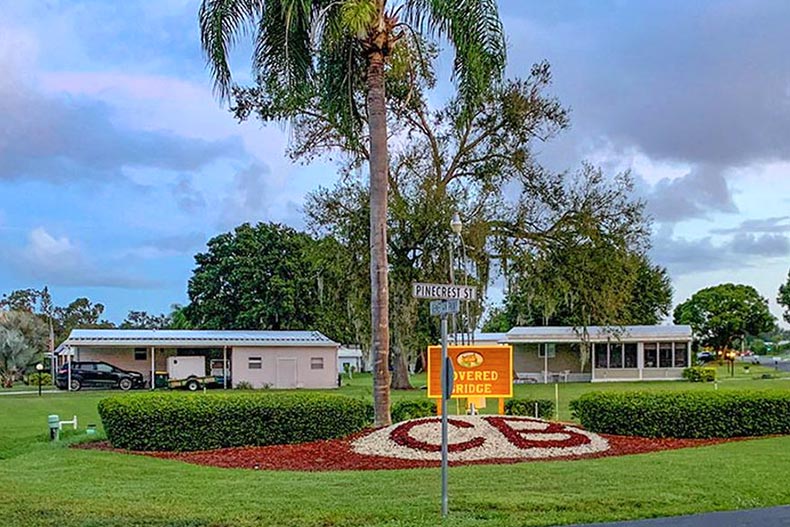 Greenery surrounding the community sign at Covered Bridge in Lake Placid, Florida.