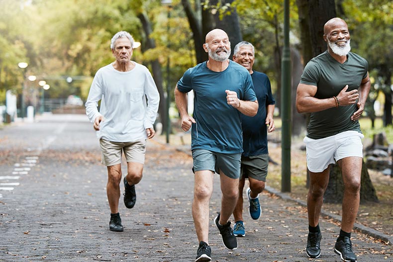 A group of retired men running on a street together in their 55+ community.