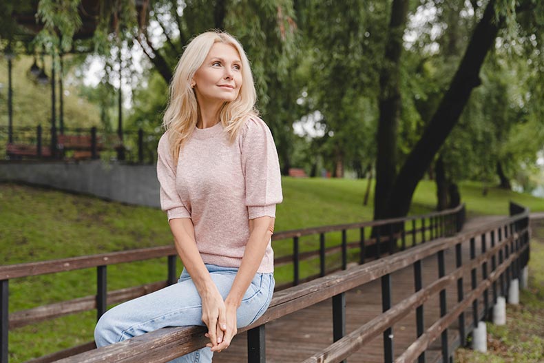 A mature woman walking alone in a park in her 55+ community.