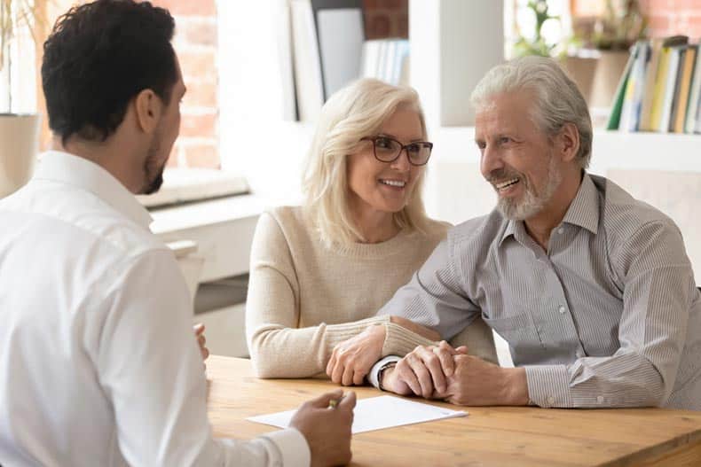 A 55+ couple meeting with a real estate agent.