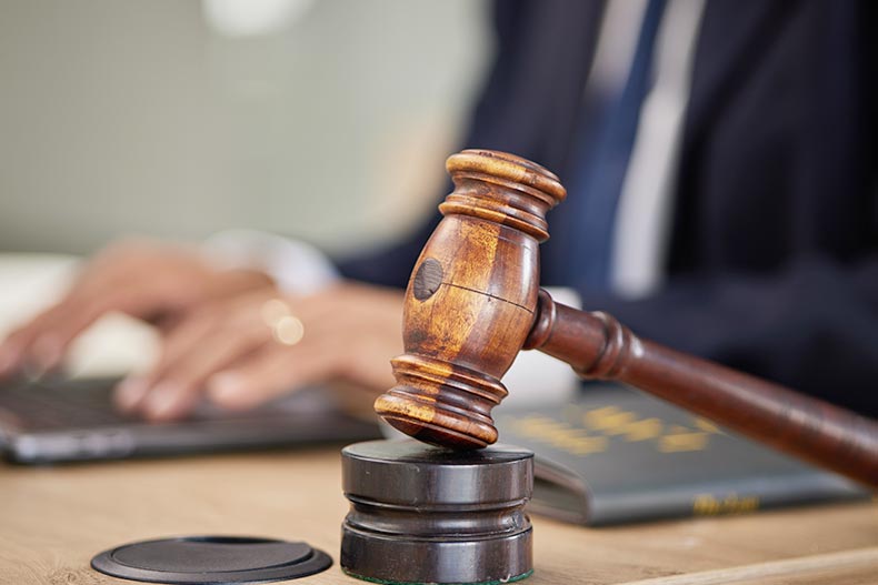 A judge doing legal research on a laptop beside a gavel.