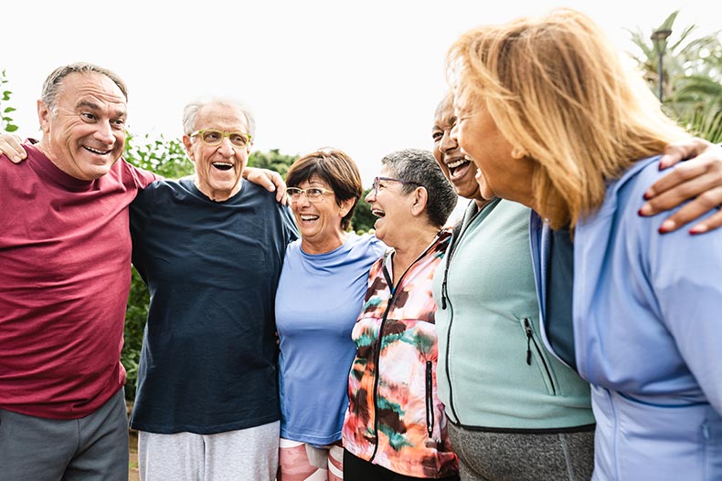 A group of senior friends having fun after an outdoor workout session in their 55+ community.