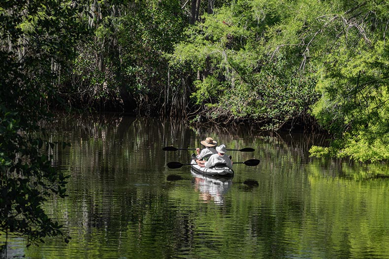 A 55+ couple enjoy canoeing at Jonathan Dickenson State Park in Hobe Sound, Florida.