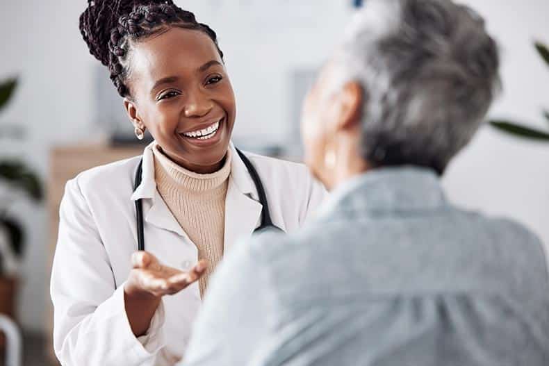 A doctor consulting a 55+ patient for healthcare feedback or support.