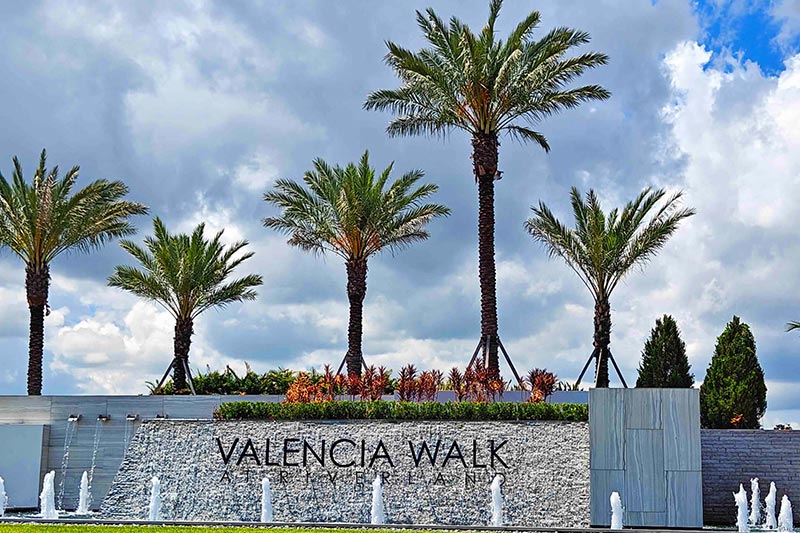 Palm trees beside the community sign for Valencia Walk at Riverland in Port St. Lucie, Florida.