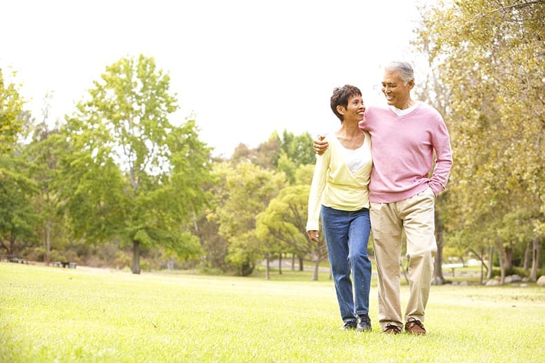 A 55+ couple walking in a park in their 55+ community.